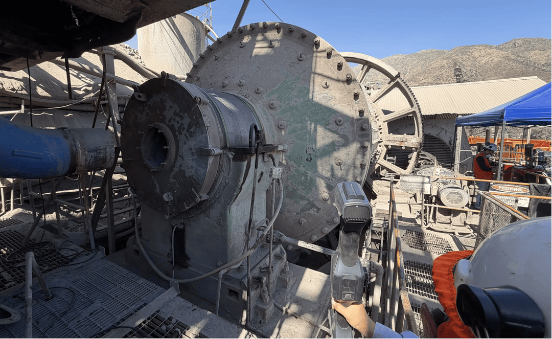 Technician scanning a large ball mill with the FreeScan Trak Nova system